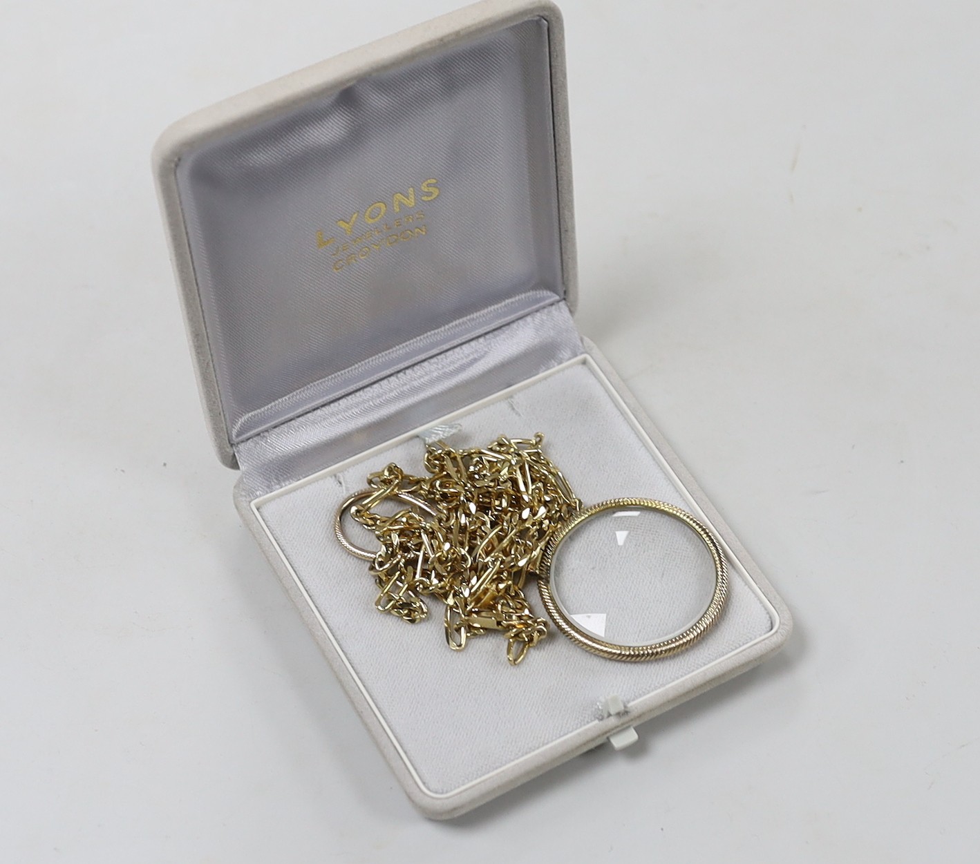 A yellow metal mounted eye glass, 85mm, suspended from a chain marked 375, 29.3 grams, 84cm.
